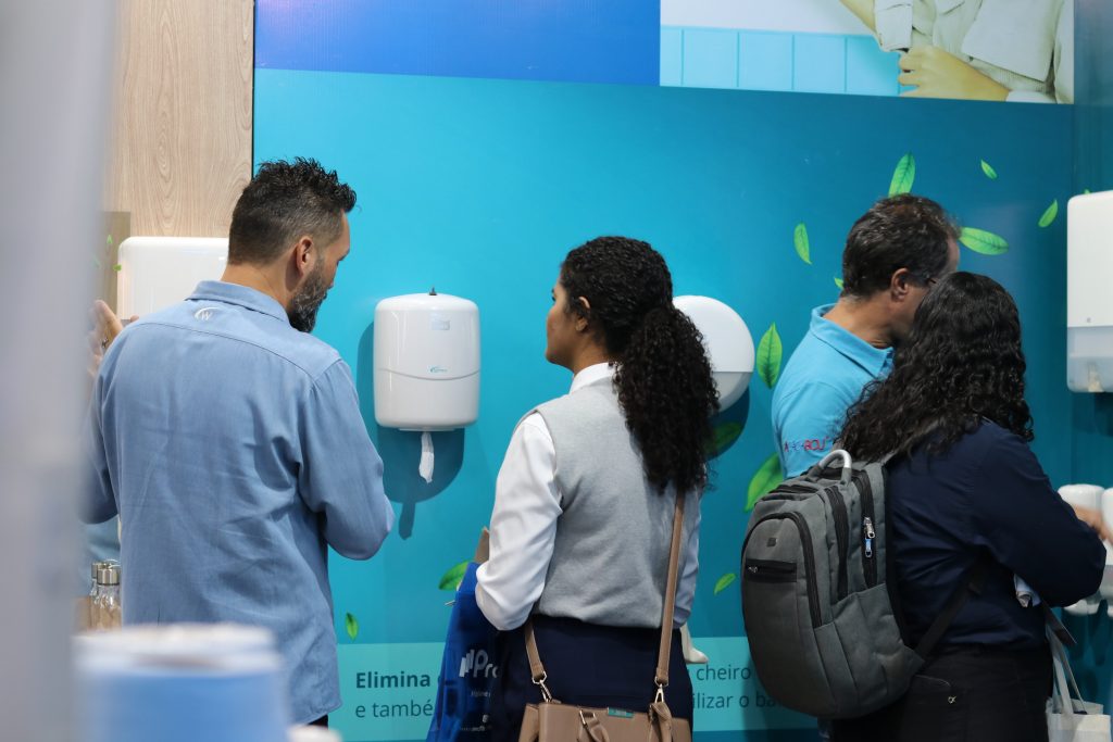 Estande da Wesco na feira InfraFM 2026 com demonstração de dispensers de higiene corporativa.